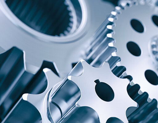 Glänzende Metallzahnräder, die ineinandergreifen und die Komplexität der Maschinenbau-Technologie verdeutlichen.