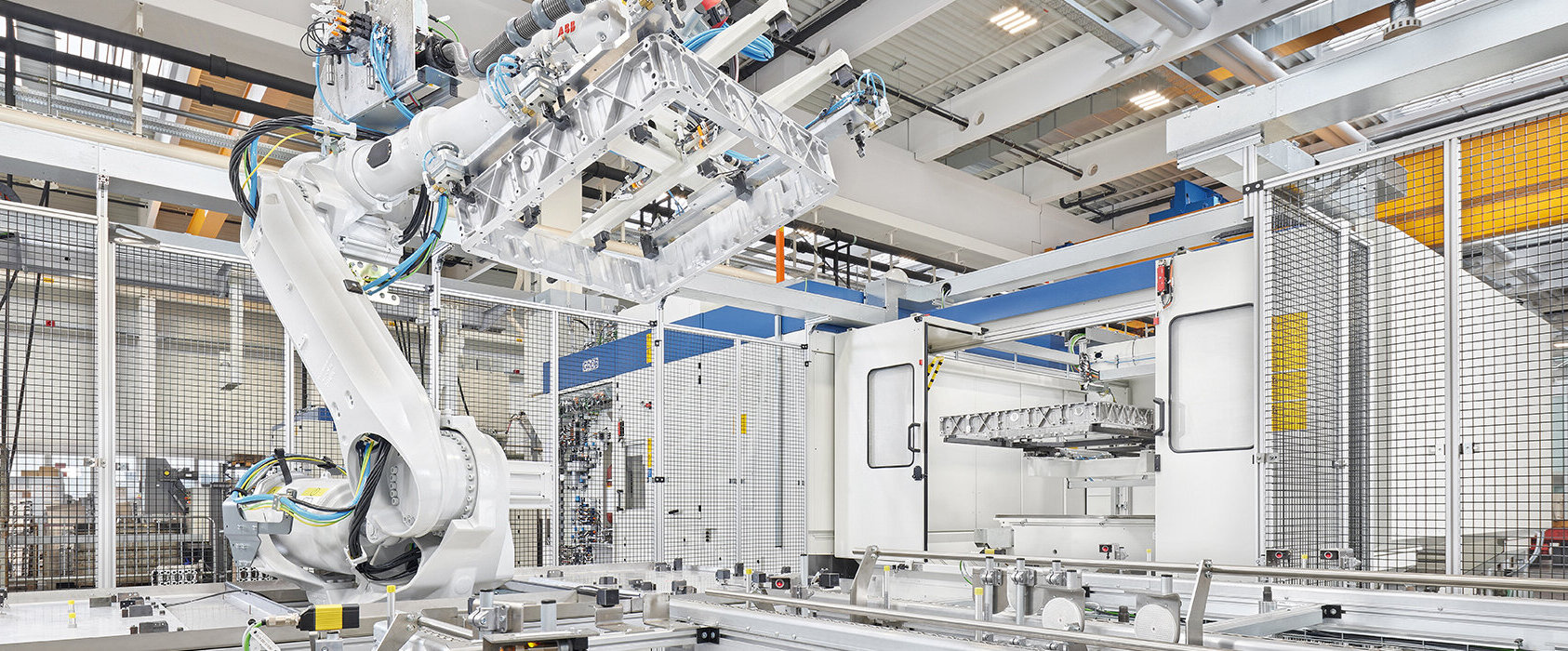 Ein hochmoderner Industrieroboter hebt ein präzise gefertigtes Bauteil in einer automatisierten Fertigungsumgebung.
