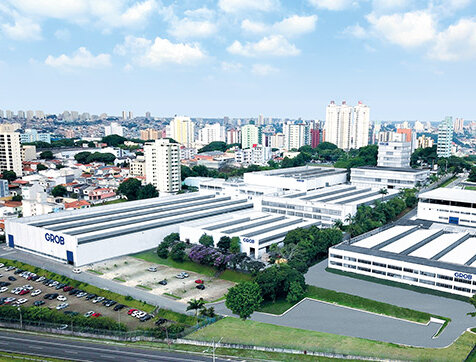 Ein Luftbild der GROB-Anlage in São Paulo zeigt moderne Produktionsgebäude und eine großzügige Parkplatzfläche.