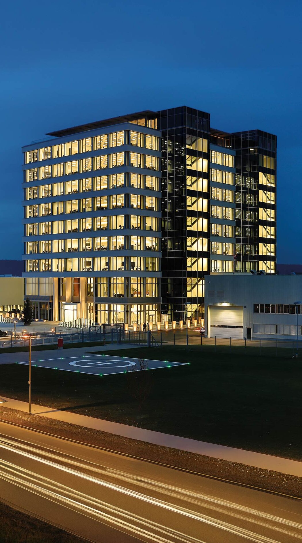 Das moderne GROB-Gebäude strahlt in der Dämmerung mit beleuchteten Fenstern und einem klaren, eleganten Design.