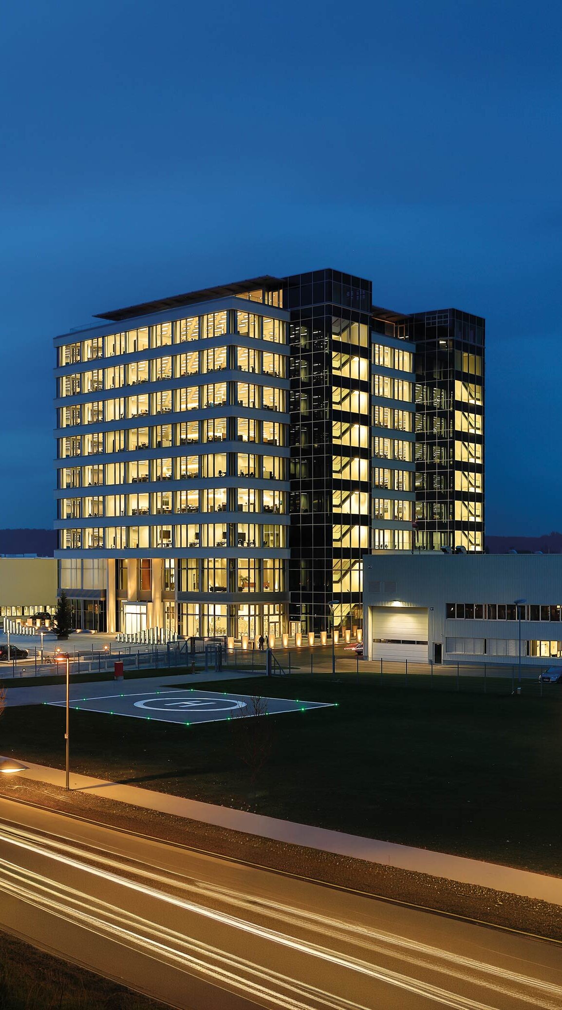 Das moderne GROB-Gebäude strahlt in der Dämmerung mit beleuchteten Fenstern und einem klaren, eleganten Design.