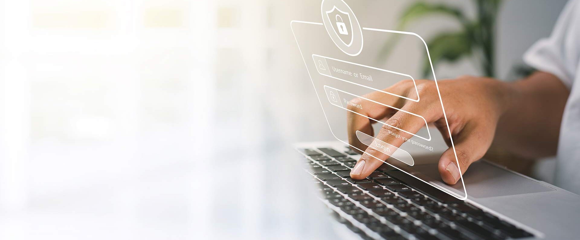 Eine Hand tippt auf einer Laptop-Tastatur, während ein digitales Anmeldefenster mit Sicherheitssymbolen angezeigt wird.
