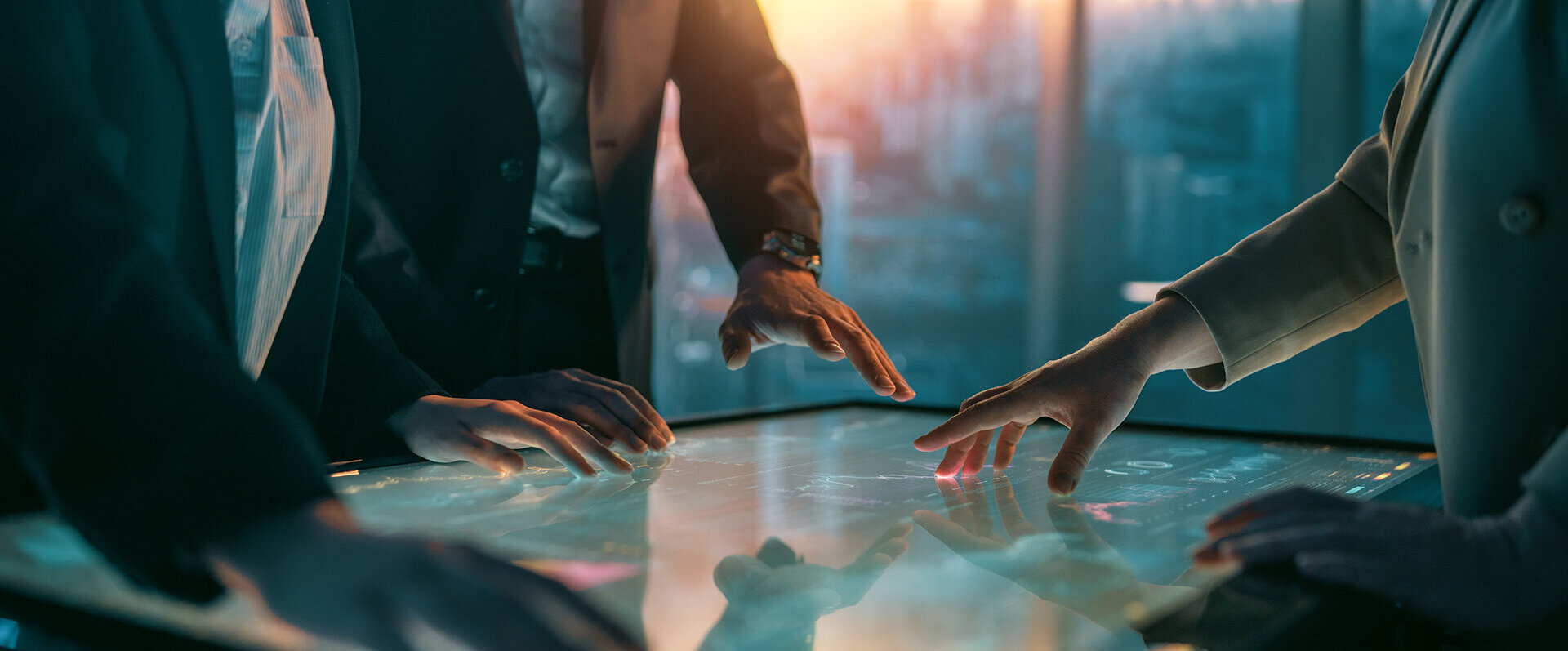Mehrere Personen in Anzügen interagieren mit einem digitalen Touchscreen, während sie strategische Ideen diskutieren.