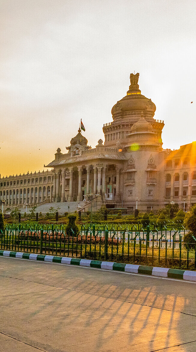 Die beeindruckende Architektur des Vidhana Soudha in Bengaluru strahlt im warmen Licht der Abendsonne.