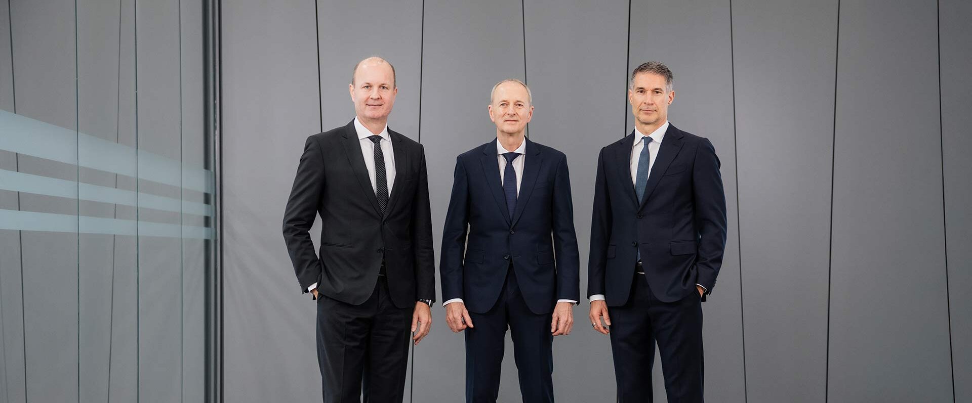 Die Geschäftsleitung von GROB posiert in einem stilvollen Raum, umgeben von minimalistischer Architektur und neutralen Farben.