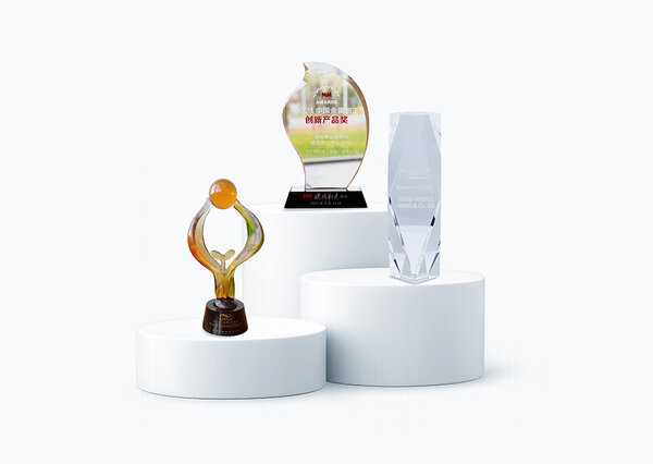 Die Trophäen von GROB, darunter eine gläserne Auszeichnung und eine kreative Figur, zeugen von herausragenden Leistungen.